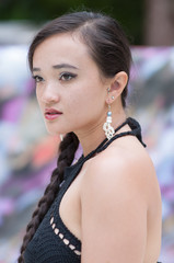 Dark haired model with black swimsuit at a pool.