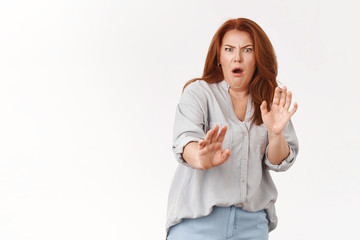 Oh gosh take away from me. Cringing displeased redhead middle-aged woman show aversion step back...