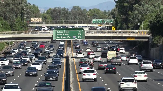 Motorcycle riders dangerously riding the white line on a Los Angeles freeway