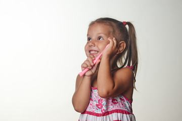 Little girl brushing teeth with toothbrush over white background with copy space