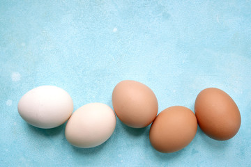 White and beige raw chicken eggs. Top view with copy space.