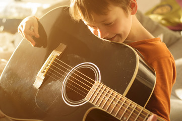 child with black acoustic guitar