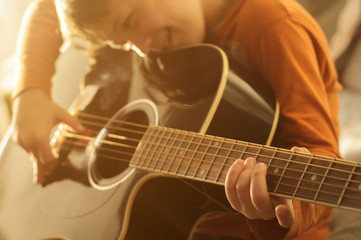child with black acoustic guitar