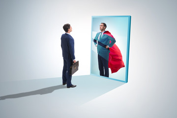 Businessman seeing himself in mirror as superhero