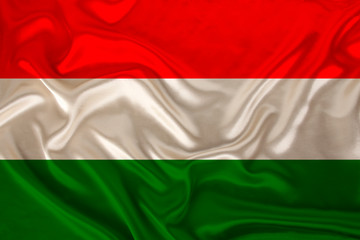 photo of the national flag of Hungary on a luxurious texture of satin, silk with waves, folds and highlights, close-up, copy space, travel concept, economy and state policy, illustration