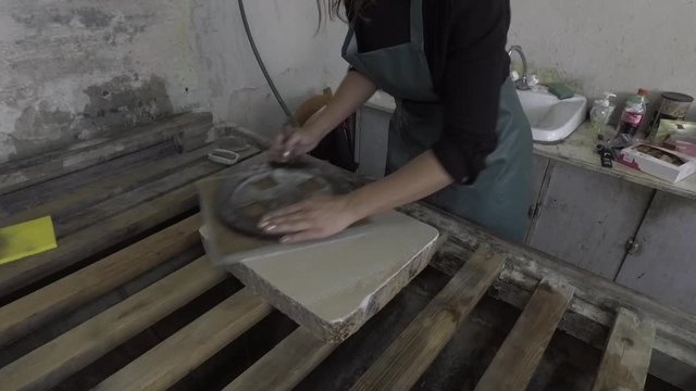 Woman artist polishing lithographic stone