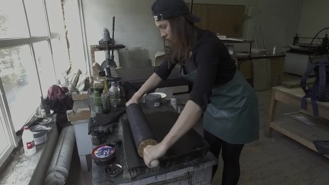 Woman delivers paint onto printing shaft