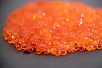 Red caviar close up on the grey stone background