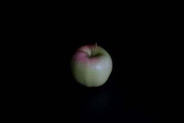 Red-pink apple on a black background