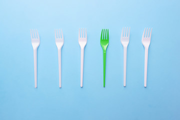 Ecological concept, zero waste. Recycling plastic forks on blue background. Concious consumption, environment care