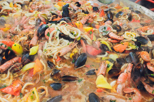 Paella seafood is cooked in a large capacity. Large.