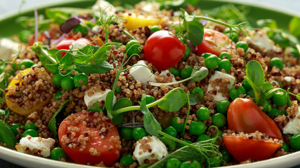 Fototapeta na wymiar Quinoa salad with green pea, mint, feta cheese, chilli flake, tomatoes and vegetables. healthy diet food