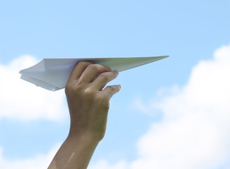 Hand holding paper airplane