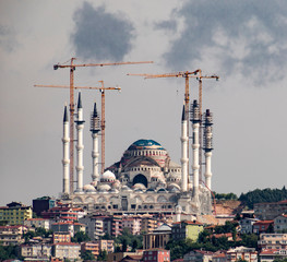 Naklejka premium Construction cranes can be seen as mosque is being restored in Istanbul, Turkey