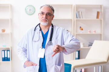 Old male doctor working in the clinic