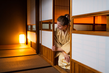 Traditional Japanese home ryokan room with gaijin caucasian woman in kimono, tabi socks opening...