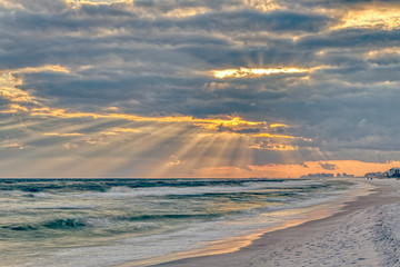 Dramatic pastel light sunset with sun rays in Santa Rosa Beach, Florida with Pensacola coastline...