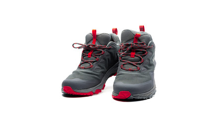 Men trekking shoes isolated on white background. Gray-red hiking shoes. Safety footwear for climbing. Adventure gear. Lightweight rubber trekking shoes with safety sole. Modern and breathable design.