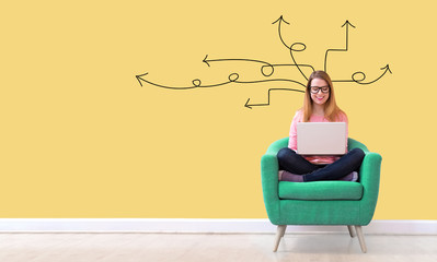 Idea arrows with young woman using her laptop in a chair