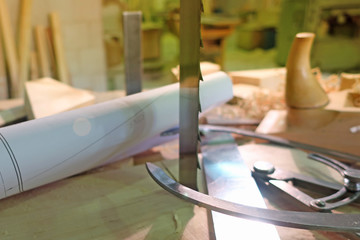 Old woodworking hand tools: wooden plane, chisel and carpentry workshop on a table covered with sawdust, side view