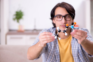 Young student physicist preparing for exam at home