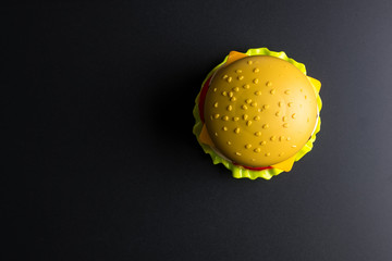 Plastic burger Fast food on black background. Children's toy. Concept of harmful artificial food. Plastic. Not organic. Not useful.