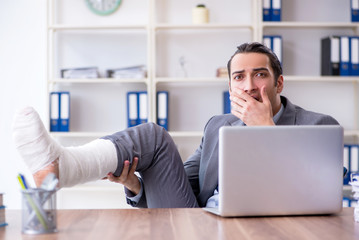 Obraz na płótnie Canvas Leg injured male employee in the office