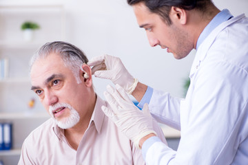 Fototapeta premium Male patient with hearing problem visiting doctor otorhinolaryng