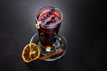 Christmas hot mulled wine with cinnamon cardamom and anise on a dark background. Glass mugs of hot...