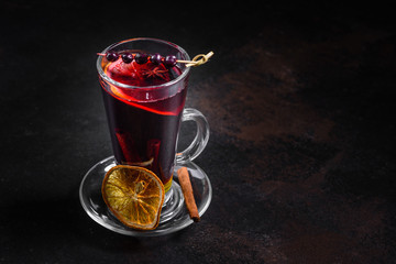 Christmas hot mulled wine with cinnamon cardamom and anise on a dark background. Glass mugs of hot mulled wine with spices and citrus fruits