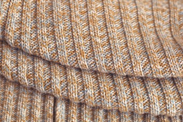 Mottled beige knitted sweater. Texture detail close up.
