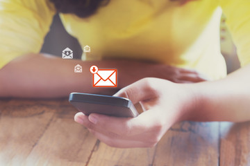 Hand of frmale using mobile phone to open new E-mail message inbox with email symbol and envelope...