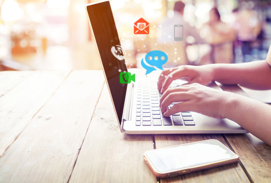 Business connection contact us and call center customer service concept. Woman hand using laptop with Icon mobile phone, telephone, e-mail address, video call and chat