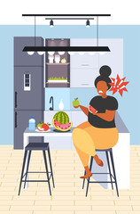 fat obese woman eating watermelon and apple fresh fruit diet african american girl healthy nutrition weight loss concept modern kitchen interior flat vertical full length