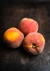 Fototapeta na wymiar Sweet ripe peaches on the rustic background. Selective focus. Shallow depth of field.