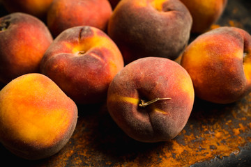 Sweet ripe peaches on the rustic background. Selective focus. Shallow depth of field.