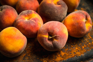 Sweet ripe peaches on the rustic background. Selective focus. Shallow depth of field.
