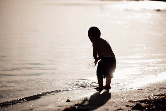 young child silouette at the beach during sunset with copy space