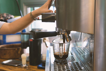 barista pouring coffee into a glass