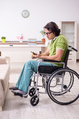 Young male student in wheelchair at home