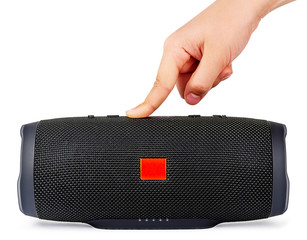 Portable Speaker with Hand Isolated on White Background. Finger Switching on the Wireless Sound...
