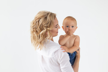 Single parent, motherhood and babyhood concept - Mother holding sweet baby girl on white background