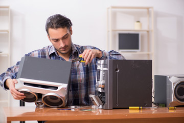 Young engineer repairing musical hi-fi system