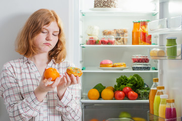 teenager girl at fridge with food