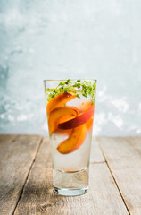 Gin based cocktail with peaches and thyme. Selective focus. Shallow depth of field.