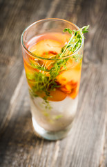 Gin based cocktail with peaches and thyme. Selective focus. Shallow depth of field.