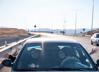 Fototapeta na wymiar Happy arabic waving of happiness while driving a car