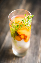 Gin based cocktail with peaches and thyme. Selective focus. Shallow depth of field.