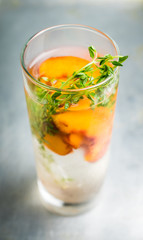 Gin based cocktail with peaches and thyme. Selective focus. Shallow depth of field.