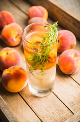 Gin based cocktail with peaches and thyme. Selective focus. Shallow depth of field.